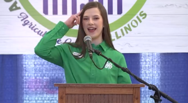 girl holding hand to head reciting 4-H pledge