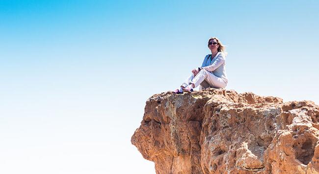 woman sitting on cliff top