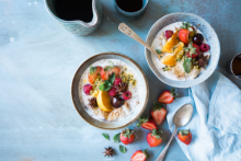 Two bowls of yogurt with fruit.