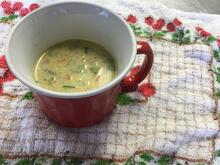 Red coffee mug with chowder inside on white towel