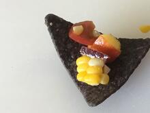 Close-up of salsa on triangular blue corn chip