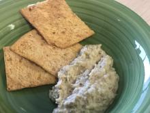 Green stripped bowl with eggplant dip and 3 pita chips