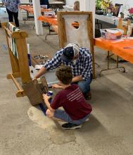 4-H boy showing his woodworking project to a judge
