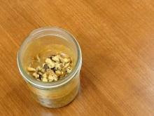 Small mason jar of overnight oats on light wood background
