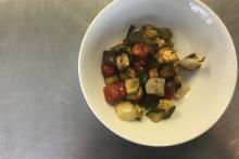White bowl with ratatouille vegetables on metal table