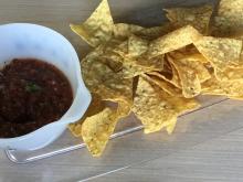 Platter with bowl of salsa and yellow tortilla chips