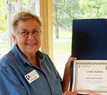 Linda Kunesh with a certificate