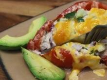 Stuffed tomato on plate with sliced avocado
