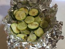Sliced squash and onion in foil