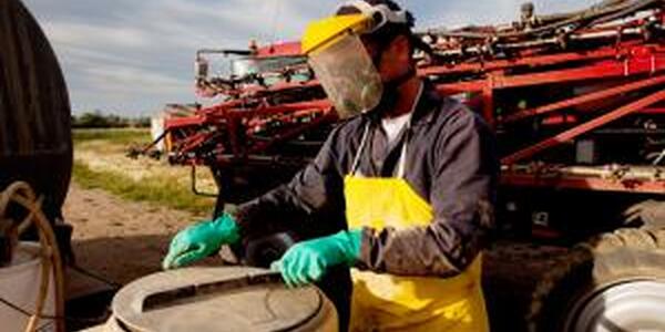 Filling a high clearance sprayer with chemical and water with proper safety equipment