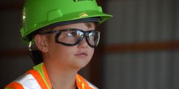 little boy in hard hat, safety glasses and safety vest