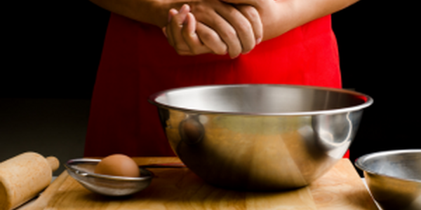 woman in red dress cracking an egg into a bowl