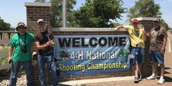 archery team in front of sign