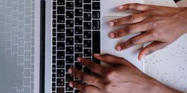 african american hands typing on laptop keyboard