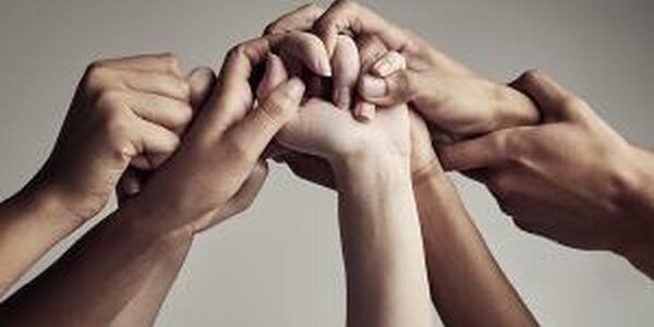 Intertwined hands of different skin tones