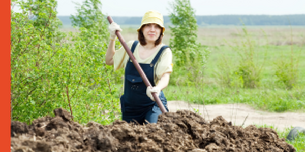 woman with a pitchfork in a compost pile