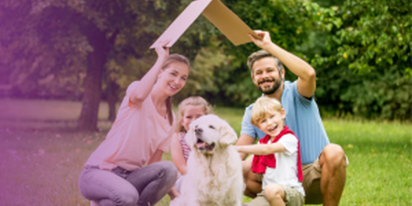 family outside in the grass holding a piece of angled cardboard above their head like a roof