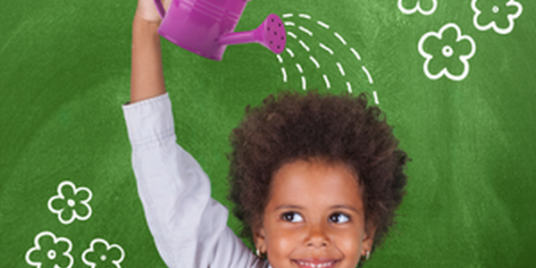 child watering head with watering can in front of a chalkboard