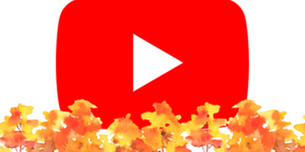 A red rectangular oval with a white play button icon in the center behind a row of trees with orange and yellow fall color.