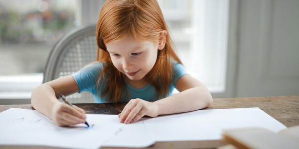 small child writing in a notebook