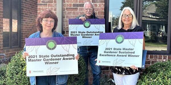 Master Gardeners holding award signs