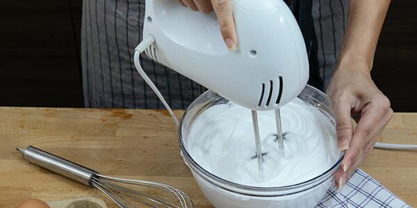 person using electric hand mixer