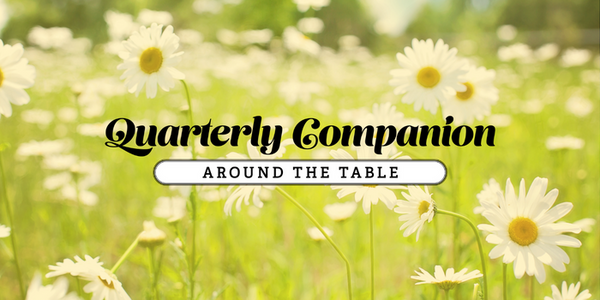 "Quarterly Companion: Around the Table" in front of a field of daisies