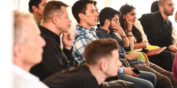 diverse group of people listening intently to presentation speaker