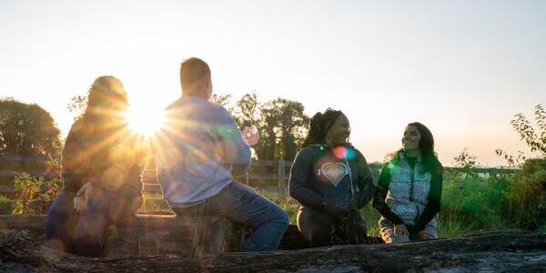 four friends sharing stories during sunset