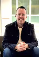 Illinois Extension team member Garrett Pauley seated in a chair