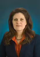 deb hagstrom has long dark hair and wears an orange shirt with navy blazer
